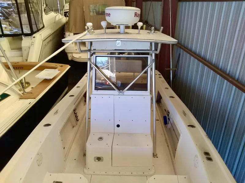 Slide: The Image of 1996 Mako 262 Center Console boat in storage, featuring a radar system and spacious deck. - 3