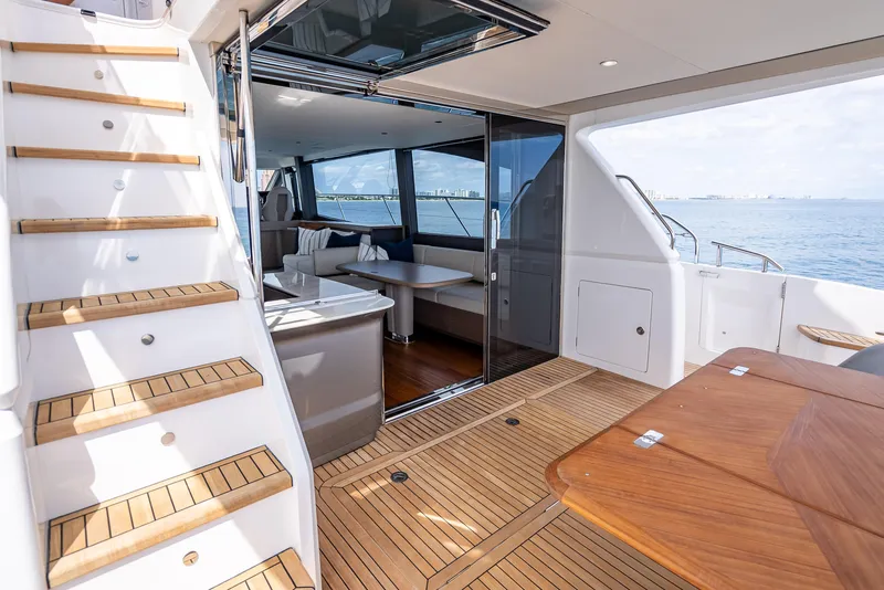 Slide: The Image of Luxurious 2023 Princess F65 yacht interior with wooden deck and elegant seating area. - 13