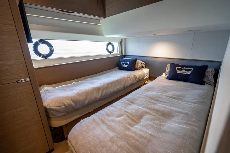 Slide: The Image of Luxurious twin cabin in 2023 Princess F65 yacht with modern decor and porthole windows. - 47
