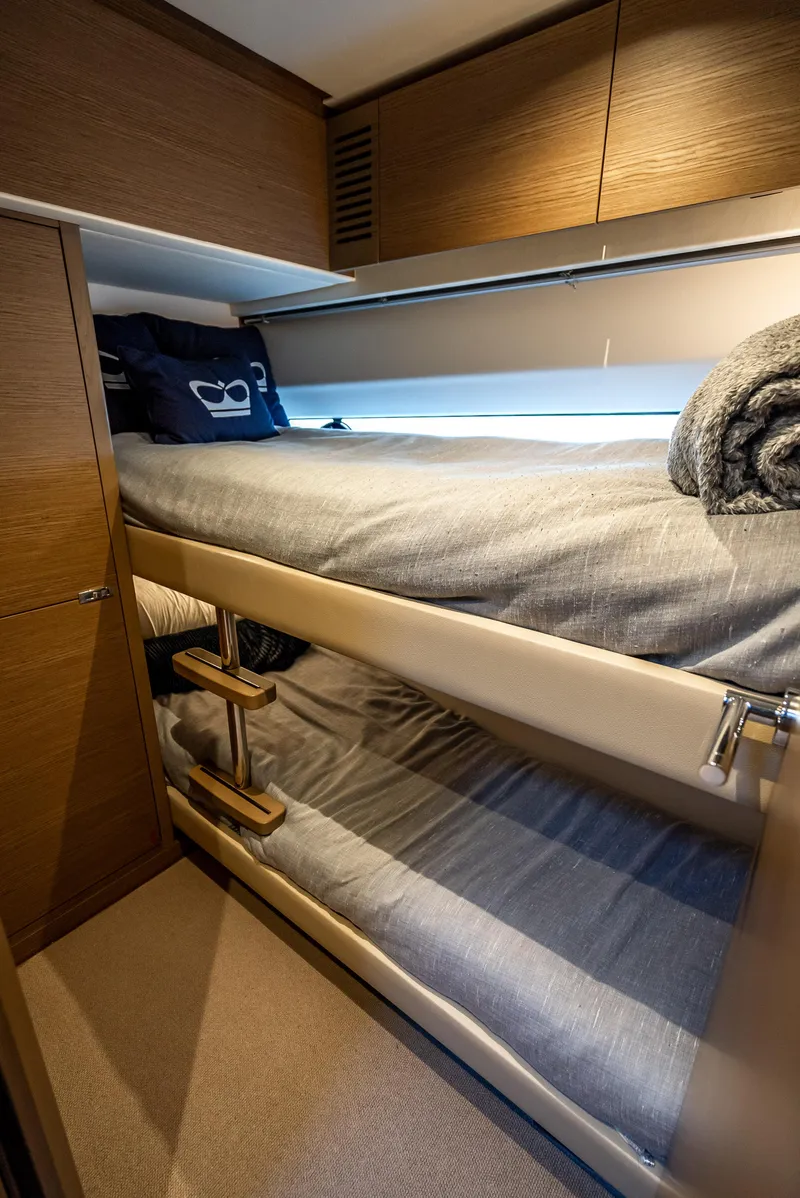 Slide: The Image of 2023 Princess F65 yacht interior with cozy bunk beds and modern wooden cabinetry. - 49