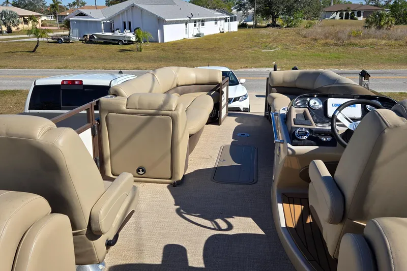 Slide: The Image of 2017 Regency 254 LE3 pontoon boat interior with beige seating and steering console. - 14