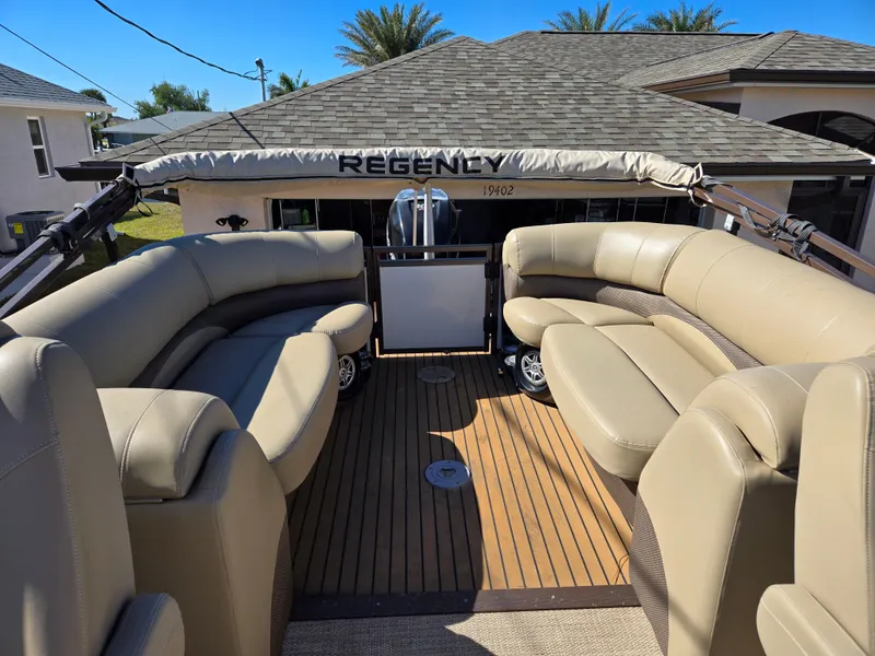 Slide: The Image of 2017 Regency 254 LE3 pontoon boat with beige seating and wooden deck. - 15