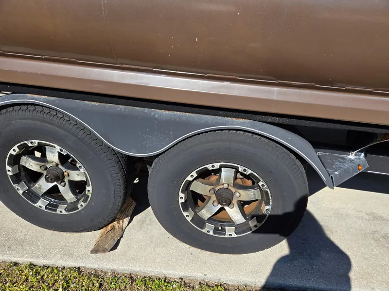 Slide: The Image of 2017 Regency 254 LE3 trailer wheels on pavement, showing dual tires and rims. - 19