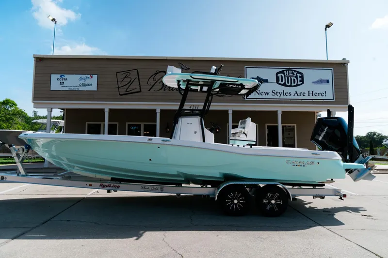 The Image of 2025 Caymas 28 HB boat on trailer in front of store, sunny day. - 1