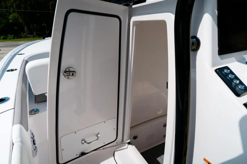 Slide: The Image of 2025 Caymas 28 HB boat interior with open storage compartment door. - 22