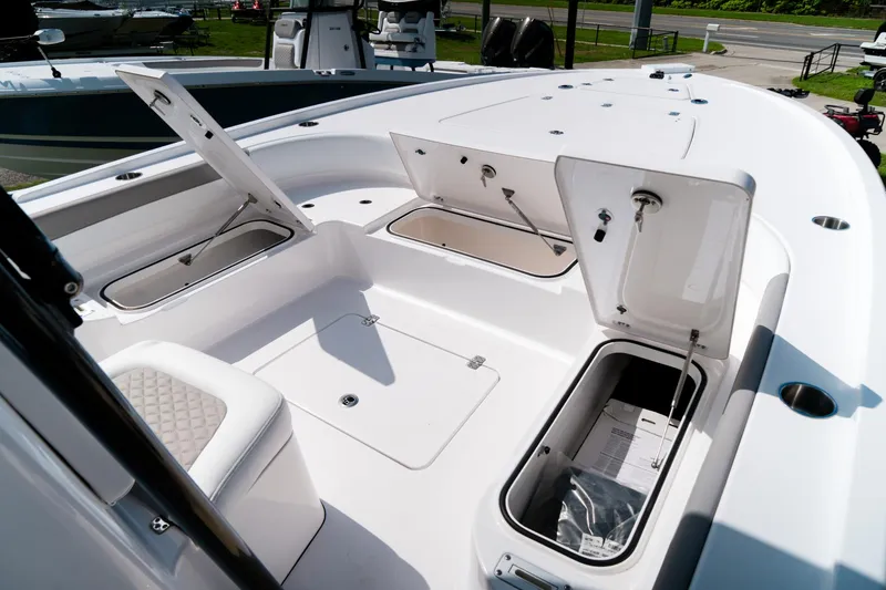 Slide: The Image of 2025 Caymas 28 HB boat deck with open storage compartments and seating. - 26