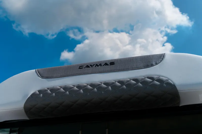 Slide: The Image of Caymas 28 HB 2025 boat detail against a bright blue sky with clouds. - 32