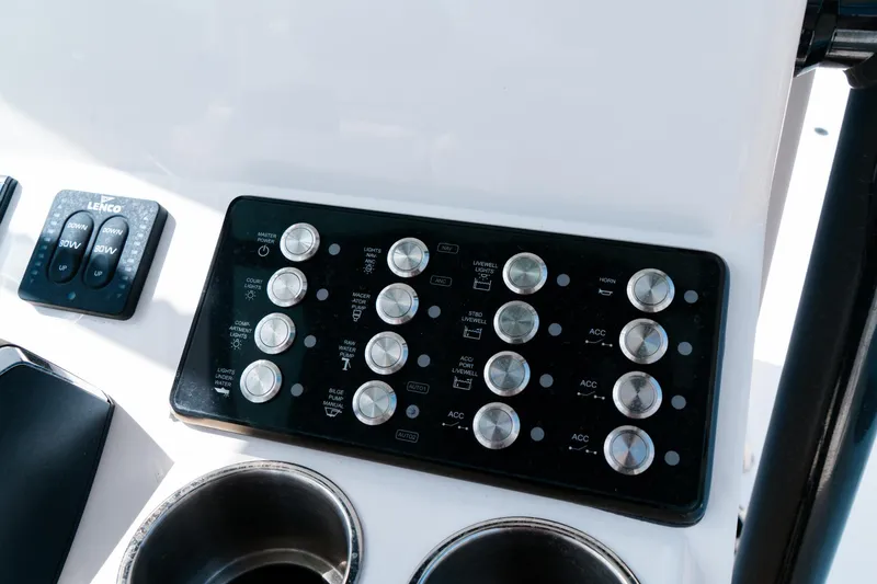 Slide: The Image of Control panel of 2025 Caymas 28 HB boat with multiple switches and cup holders. - 40