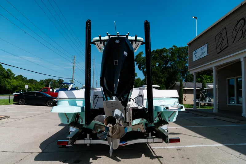 Slide: The Image of 2025 Caymas 28 HB boat rear view in parking lot, showcasing powerful engine and sleek design. - 5