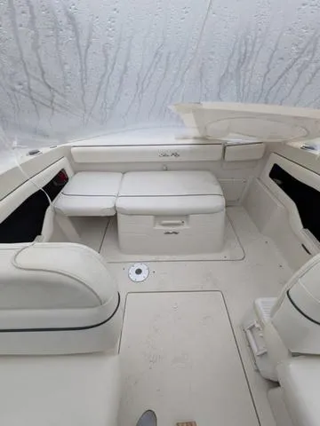 Slide: The Image of 1999 Sea Ray 215 Express Cruiser interior with white seating and storage compartments. - 10