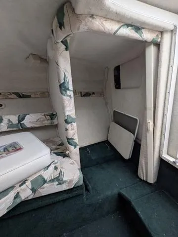 Slide: The Image of 1999 Sea Ray 215 Express Cruiser interior with floral upholstery and green carpet. - 16