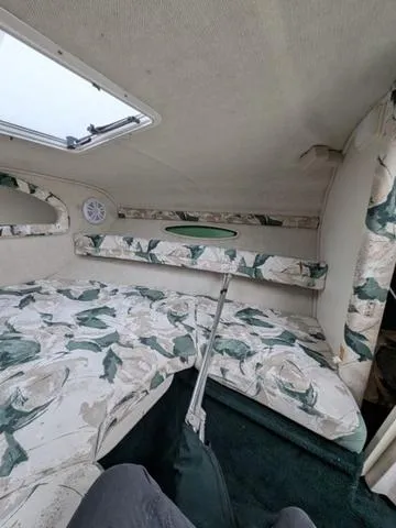 Slide: The Image of 1999 Sea Ray 215 Express Cruiser cabin interior with floral upholstery and overhead hatch. - 19