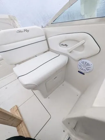 Slide: The Image of 1999 Sea Ray 215 Express Cruiser interior seating with white upholstery and speaker. - 21