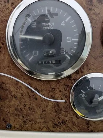 Slide: The Image of 1999 Sea Ray 215 Express Cruiser dashboard with RPM gauge and odometer. - 23