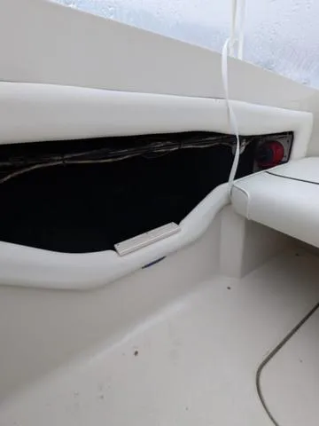 Slide: The Image of Interior view of a 1999 Sea Ray 215 Express Cruiser boat, featuring seating and storage. - 26