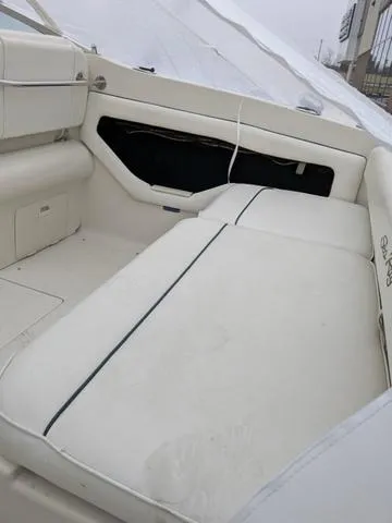 Slide: The Image of 1999 Sea Ray 215 Express Cruiser interior with white seating and storage compartments. - 30