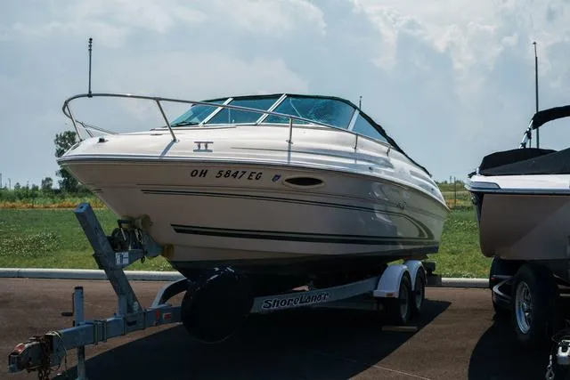 Slide: The Image of 1999 Sea Ray 215 Express Cruiser on trailer, parked outdoors. - 5