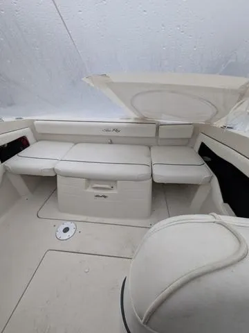 Slide: The Image of 1999 Sea Ray 215 Express Cruiser interior with white seating and storage compartments. - 7