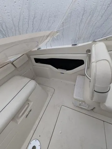 Slide: The Image of 1999 Sea Ray 215 Express Cruiser interior with white seating and sleek design. - 9