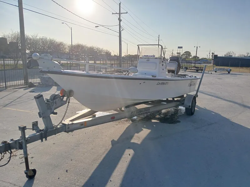 Slide: The Image of 2006 Kenner 21 boat with Lowrance equipment, parked outdoors near a modern building. - 10