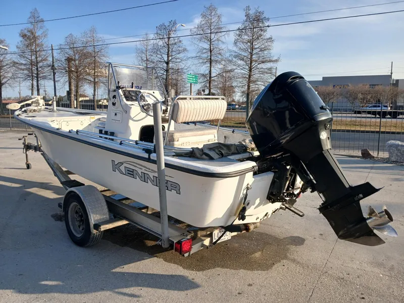 Slide: The Image of 2006 Kenner 21 boat with seating, parked outdoors near a fence. - 11