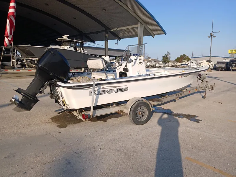 Slide: The Image of 2006 Kenner 21 boat with fishing gear and Lowrance equipment, parked outdoors. - 12