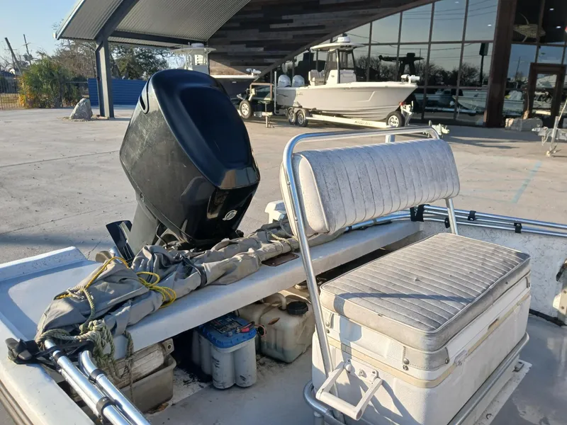 Slide: The Image of 2006 Kenner 21 boat on trailer with outboard motor, parked outdoors. - 5