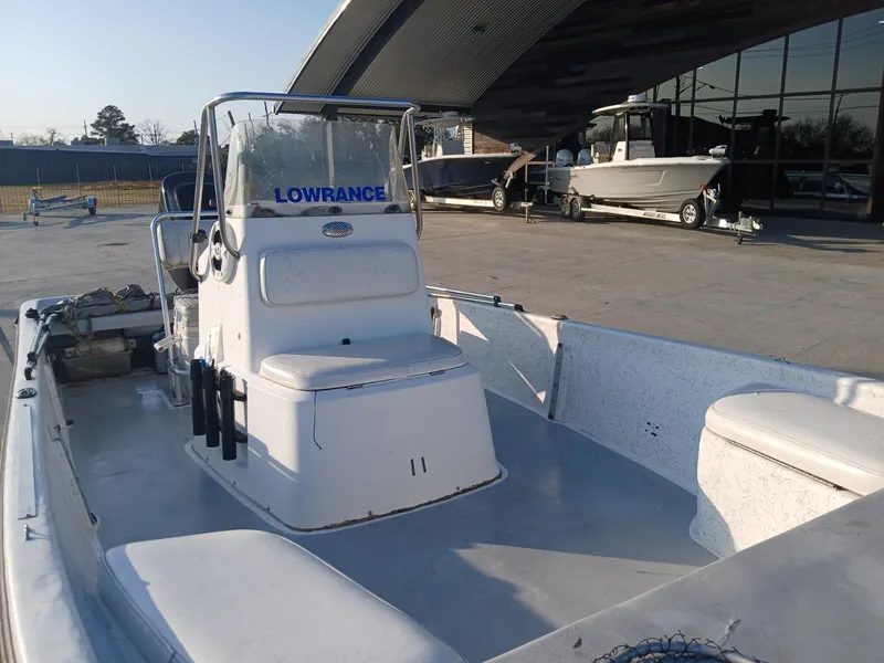 Slide: The Image of 2006 Kenner 21 boat with console and seating, parked outdoors near trees and road. - 7