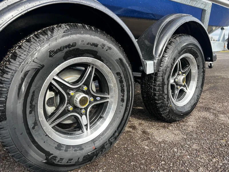 Slide: The Image of Trailer wheels of a 2025 Thunder Jet 210 Luxor boat on asphalt. - 14