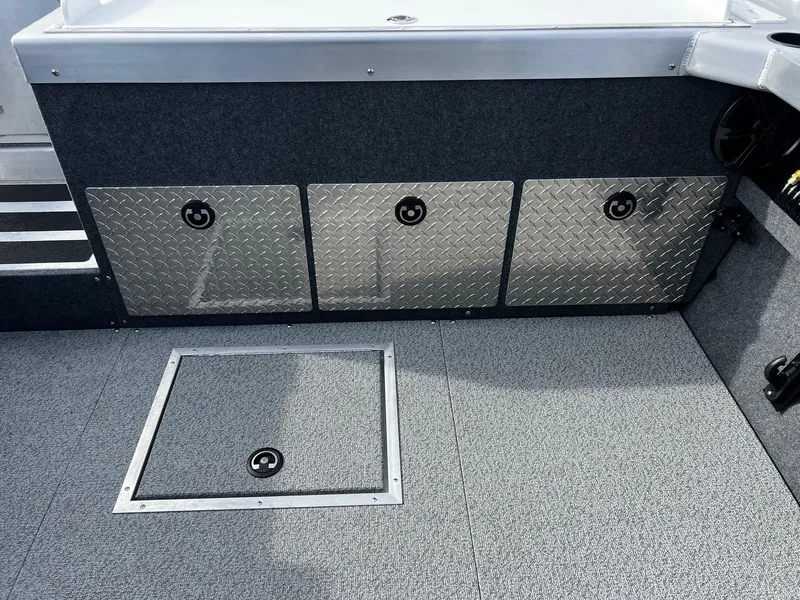 Slide: The Image of 2025 Thunder Jet 210 Luxor boat interior with storage compartments and textured flooring. - 29