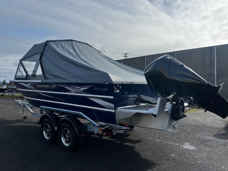 Slide: The Image of 2025 Thunder Jet 210 Luxor boat with covered cabin and outboard motor on trailer. - 4