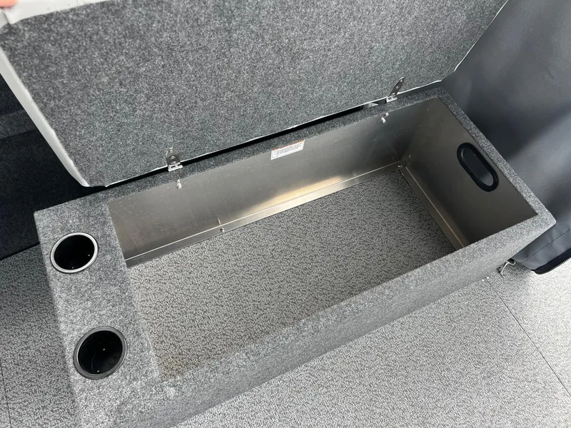 Slide: The Image of 2025 Thunder Jet 210 Luxor storage compartment with cup holders, open lid view. - 45
