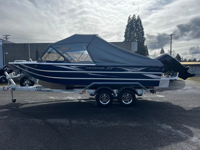 Slide: The Image of 2025 Thunder Jet 210 Luxor boat on trailer, covered, parked outdoors. - 5