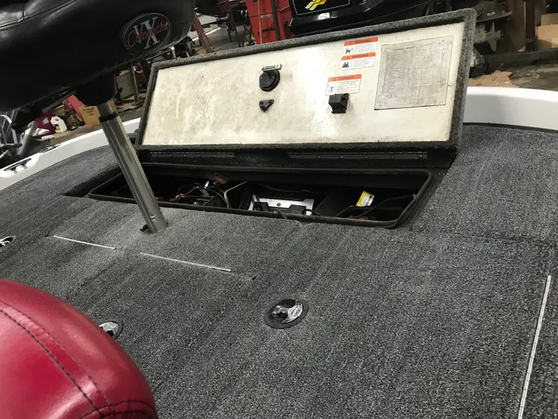 Slide: The Image of 2004 Ranger 519 VX/VS boat interior with open storage compartment and red seat. - 29