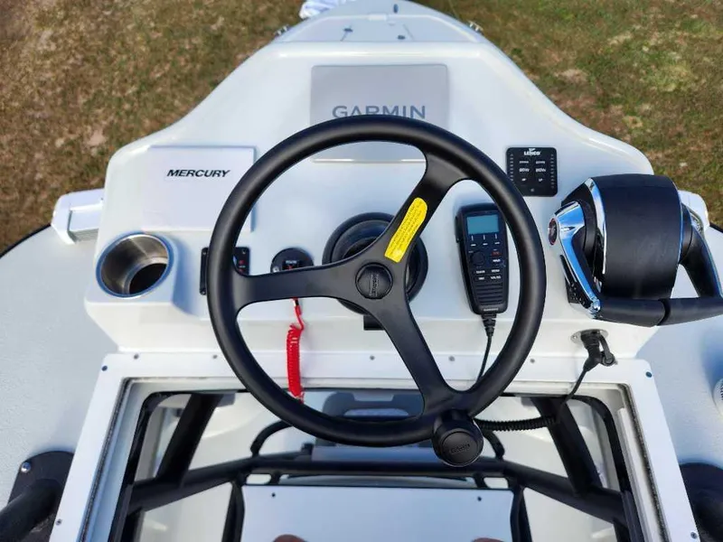 Slide: The Image of 2025 Caymas 281 HB boat dashboard with steering wheel, Garmin display, and Mercury controls. - 10