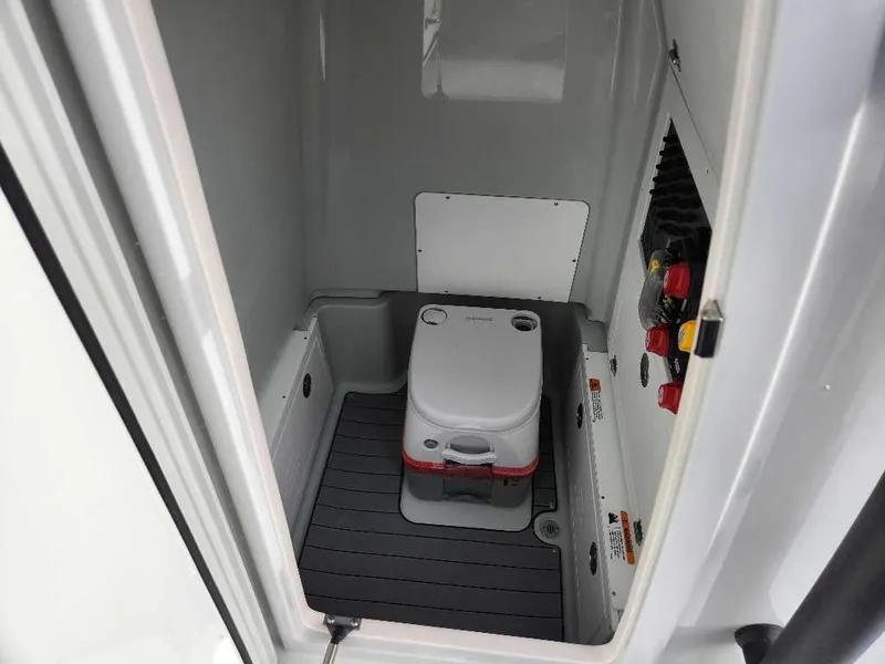 Slide: The Image of 2025 Caymas 281 HB boat interior with portable toilet and control panel. - 14