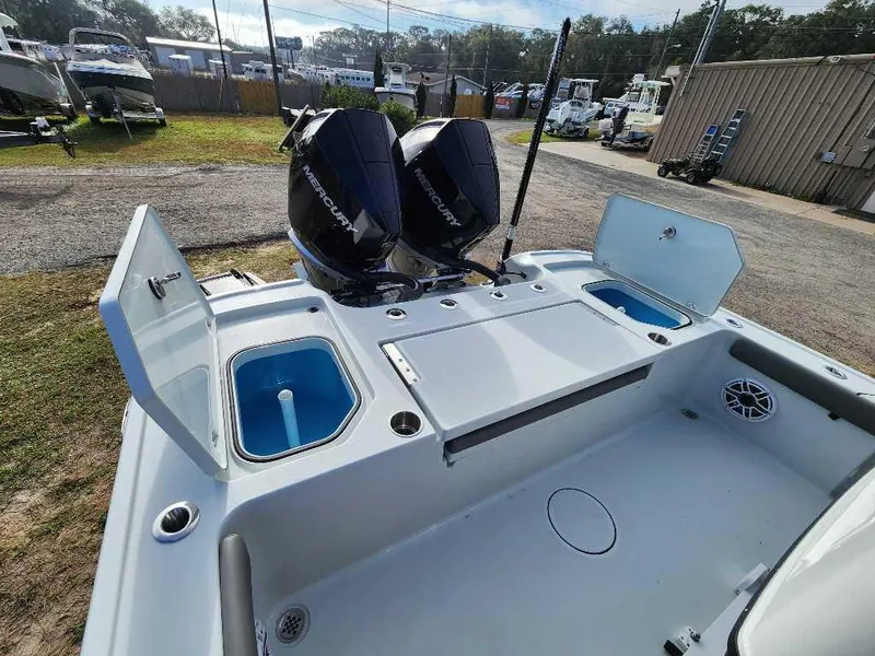 Slide: The Image of 2025 Caymas 281 HB boat with dual Mercury engines, open storage compartments, and clean deck. - 21