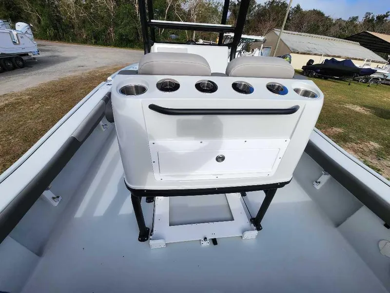 Slide: The Image of 2025 Caymas 281 HB boat interior with seating and cup holders, parked outdoors. - 22