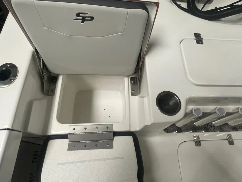 Slide: The Image of 2025 Sea Pro 230 Bay boat interior with storage compartment and rod holders. - 12