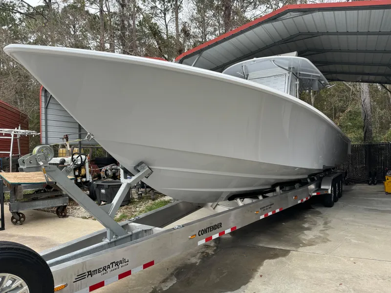 The Image of 2026 Contender 39 ST boat on trailer under a metal canopy. - 1