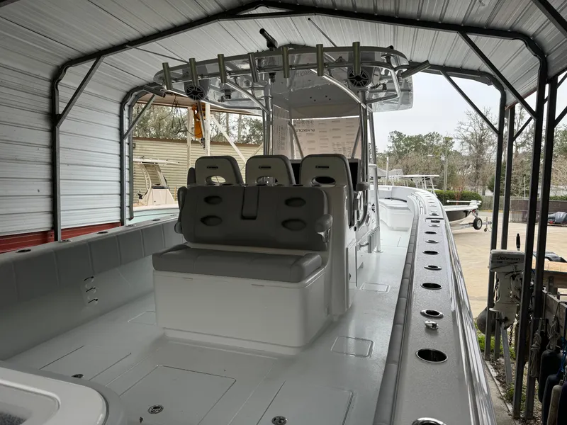 Slide: The Image of 2026 Contender 39 ST boat under a metal canopy, showcasing seating and deck layout. - 11