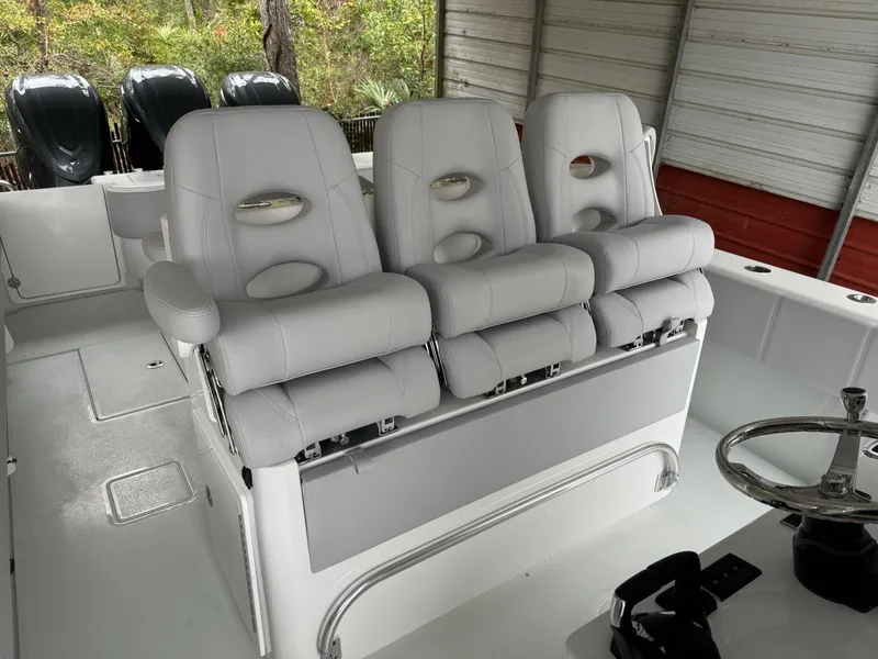 Slide: The Image of 2026 Contender 39 ST boat with three white cushioned seats and steering wheel. - 13