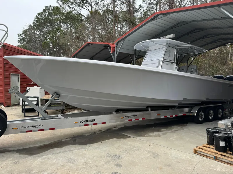 Slide: The Image of 2026 Contender 39 ST boat on trailer under a metal canopy. - 3