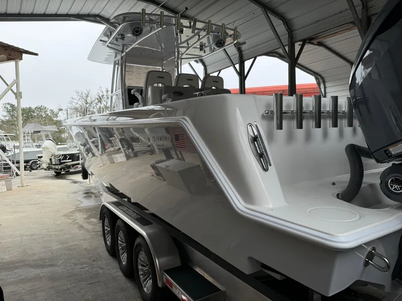 Slide: The Image of 2026 Contender 39 ST boat in a covered storage area, showcasing sleek design and triple-axle trailer. - 9