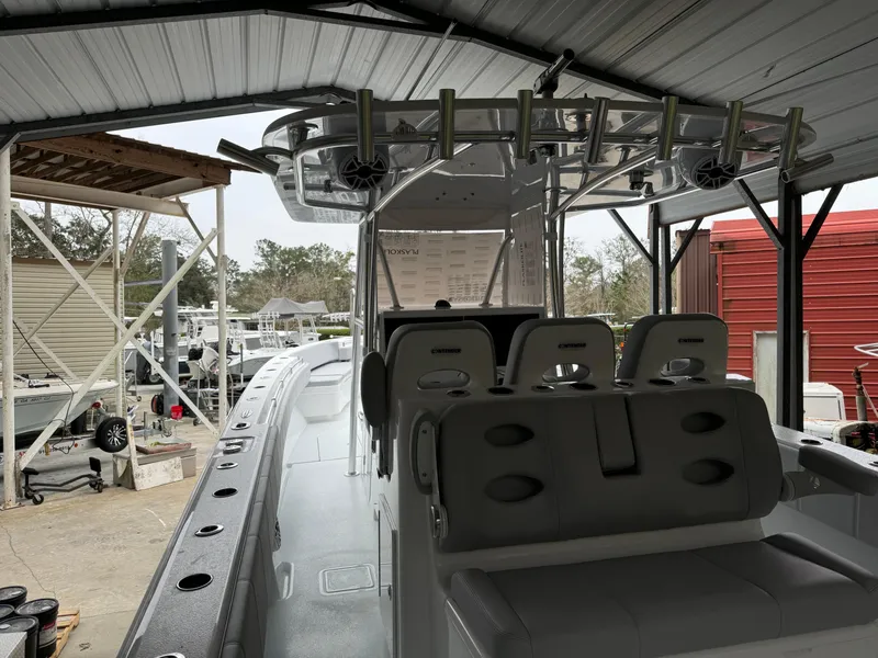 Slide: The Image of 2026 Contender 39 ST boat interior under a metal canopy, showcasing seating and rod holders. - 12