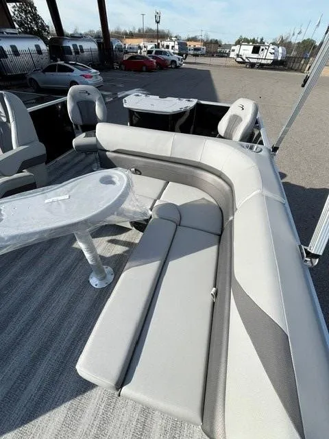 Slide: The Image of 2025 Bennington 18 SXFSE pontoon boat with gray seating and table, parked outdoors. - 10