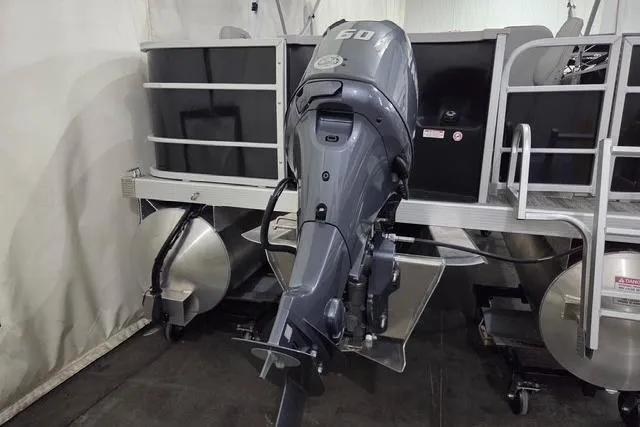 Slide: The Image of 2025 Bennington 18 SXFSE pontoon boat with 60 HP outboard motor in storage. - 14