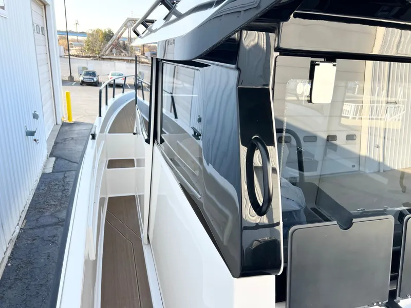 Slide: The Image of 2025 Navan C30 boat with sleek black and white design, docked outdoors. - 10