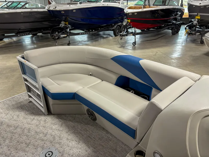 Slide: The Image of 2025 Trifecta 24 UL LE pontoon boat interior with gray and blue seating in showroom. - 4