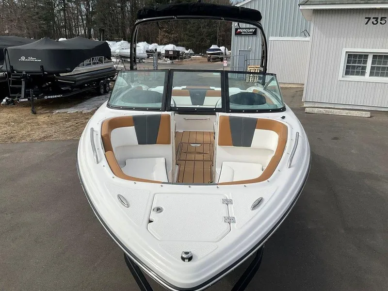 Slide: The Image of 2025 Chaparral 23 SSi boat with open bow seating, parked outdoors. - 19